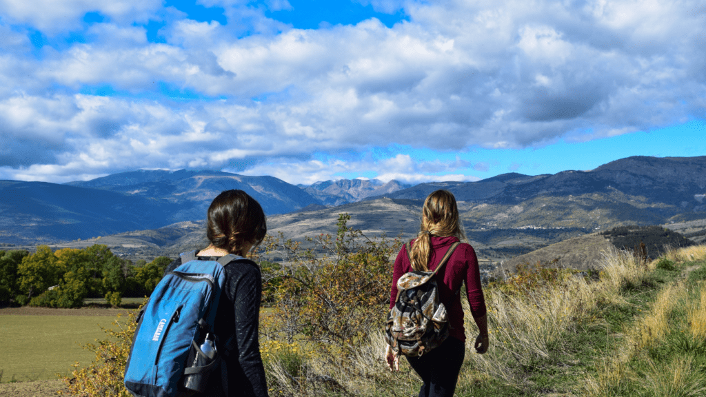 A couple with backpacks hiking in the mountains