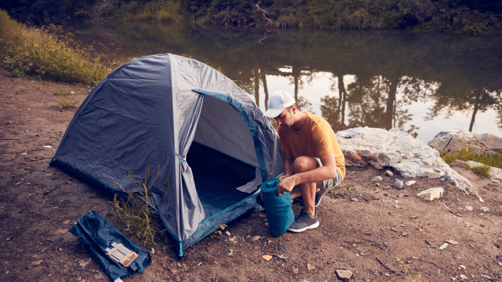 a person setting up a tent near a river