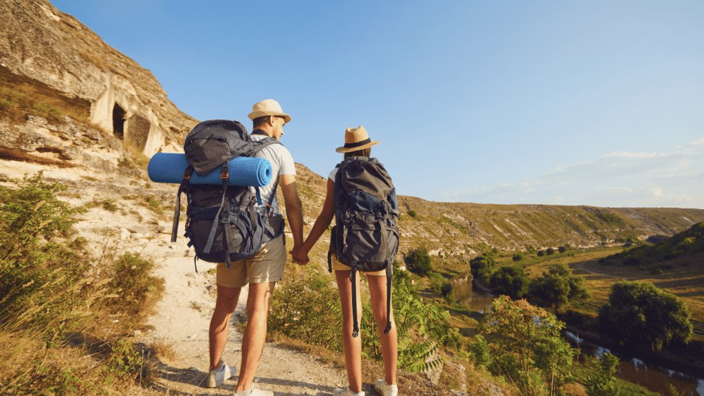 A couple with backpacks hiking in the mountains