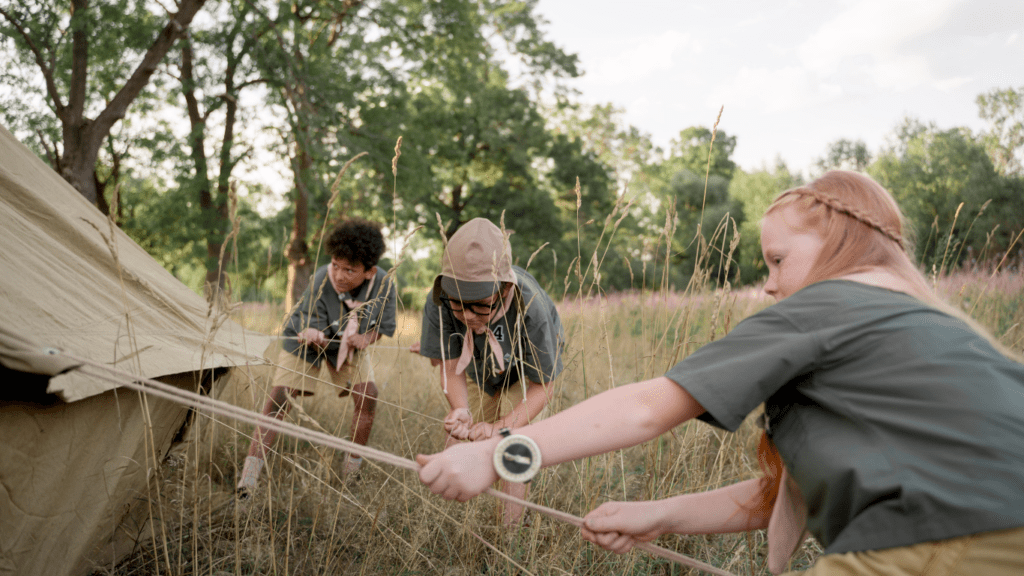 a group of people are setting up a tent in a field