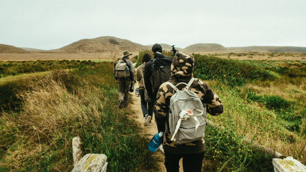 a group of people with backpacks walking on a trail