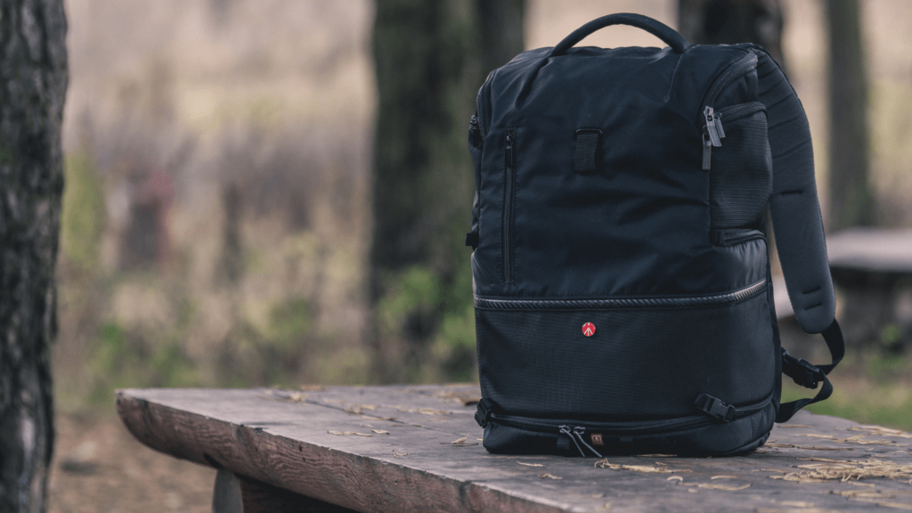 A backpack sitting on top of a wooden bench