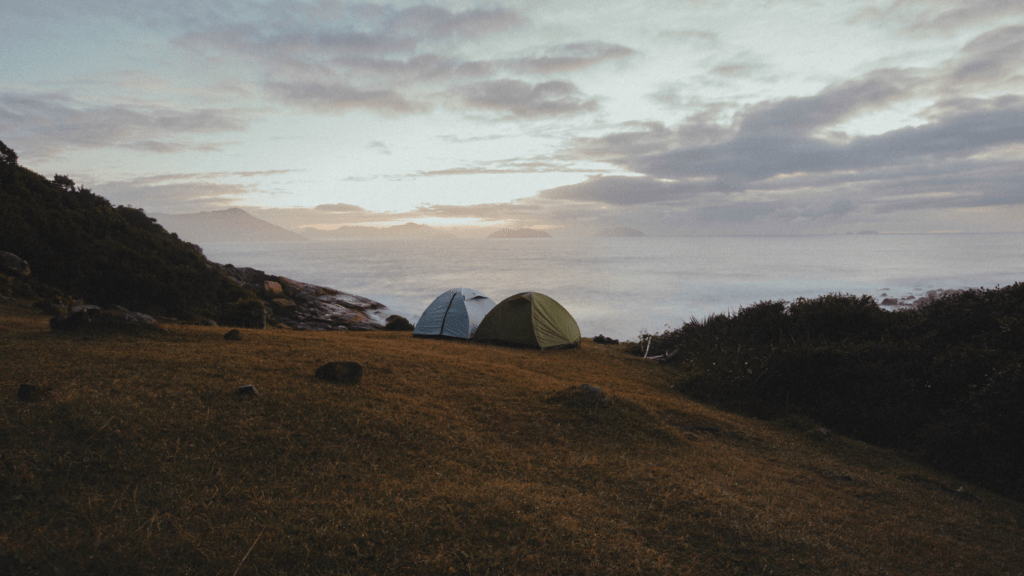 tents sit on top of a hill overlooking the ocean