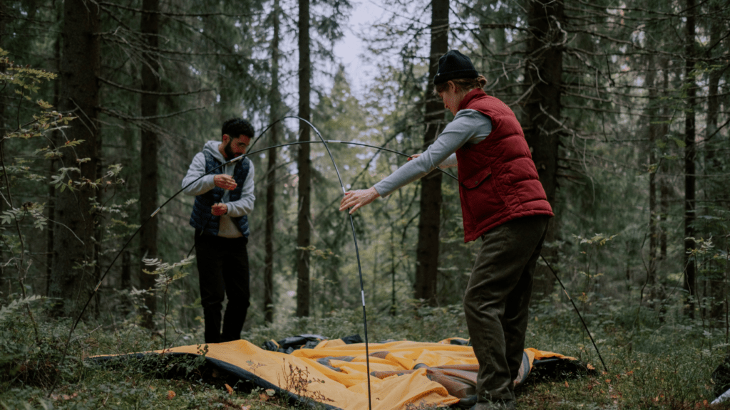 a group of people are setting up a tent in a field