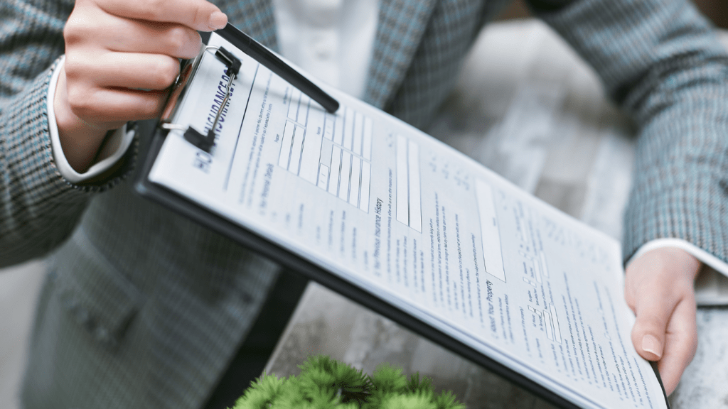 a person in a business suit is holding a clipboard and writing on it