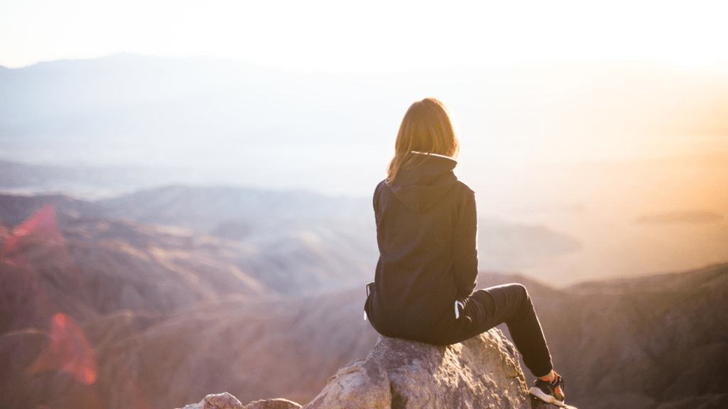 a person sitting on top of a mountain