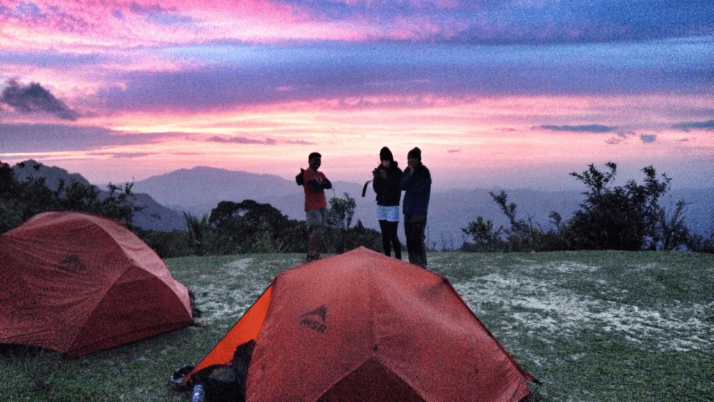 a person standing in front of a tent at sunset