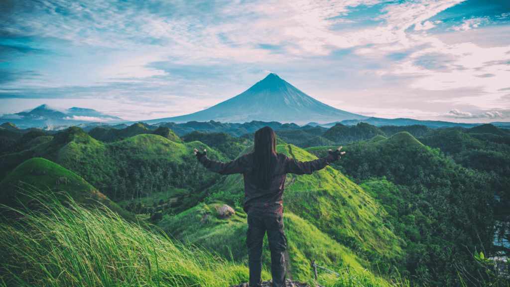 a person standing on top of a mountain overlooking a valley