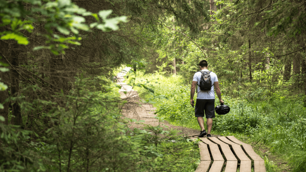 a person walking down a trail in the woods