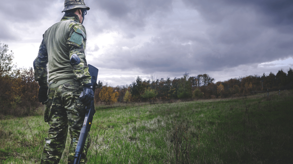 a person with a rifle in the woods