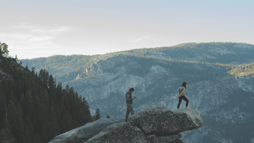 two people with backpacks walking down a trail